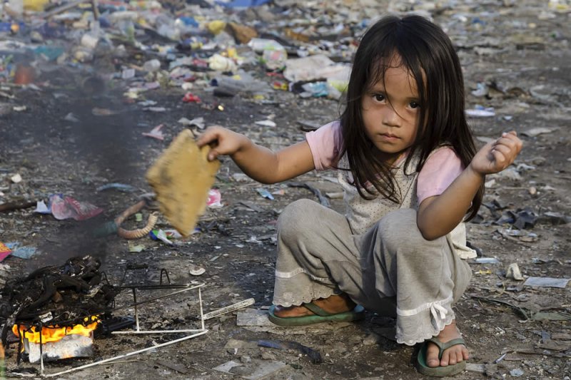 Ein Mädchen verbrennt Müll